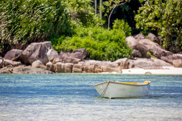 Naklejka na ściany i meble Boat on the shore of a tropical island. Pleasure boat moored on the shore of the resort. Beautiful tropical landscape of the Seychelles.