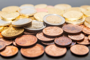 Coins and euro cents, on white surface. Wealth, savings, and rate hikes. 