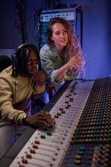 Young couple using musical keyboard to record a song in the recording studio
