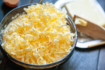 Grated butter for baking on table. Baking ingredients for shortbread pastry: grated butter, flour, eggs, sour cream on wooden background