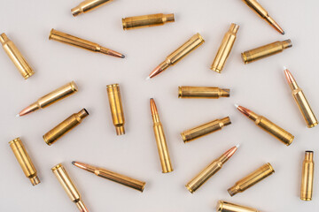 Pile of rifle bullets isolated on grey background. Top view.