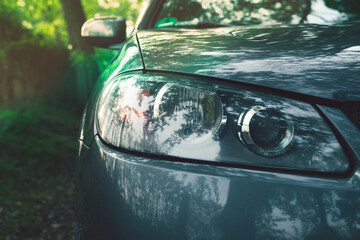 Car front lamp, lots of glare and light reflections.