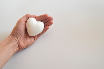 man holding white heart in palm. Organ donation and insurance concept. World heart health concept. World organ donation day. Concept of healthy heart for healthy life. selective focus