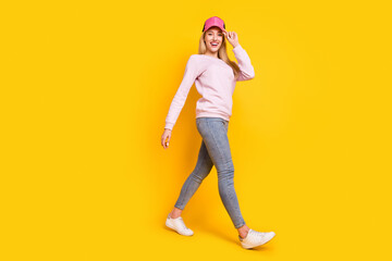 Fototapeta na wymiar Full length profile side photo of young cheerful girl happy positive smile go walk step meeting isolated over yellow color background