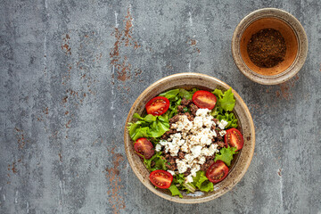 Fresh salad with whole grain teff, cheese and mitmita spice blend. Ethiopian cuisine.