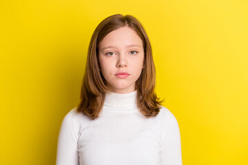 Photo of serious young charming little girl wear white turtleneck isolated on shine yellow color...