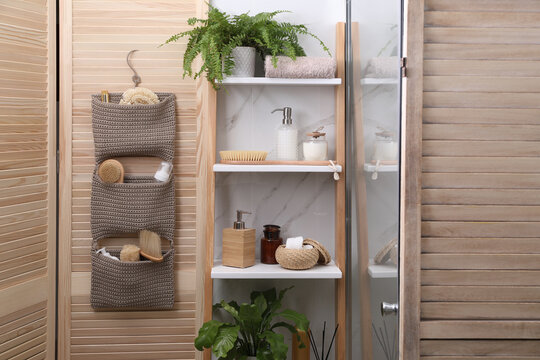 Shelving unit and organizer with essentials in bathroom. Stylish accessory
