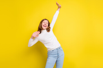 Photo of happy positive little young girl good mood dance enjoy free time isolated on yellow color...