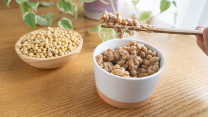 日本の納豆と生大豆。納豆を箸で混ぜる。	
