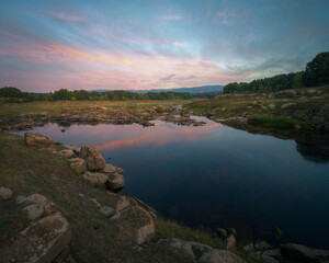 Sunset cloudscape reflected in the calm waters of the river