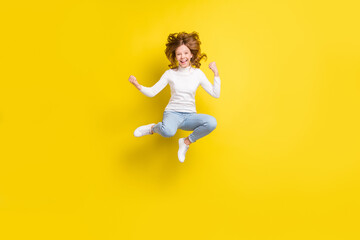 Full length photo of young excited girl happy positive smile jump rejoice victory isolated over...