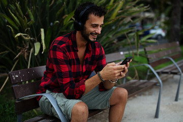 Obraz premium Young man listening to music. Urban fashion man with headphones enjoying the city.