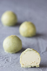 Green truffles with matches and limes on a gray background.