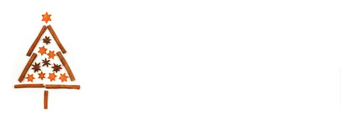 Christmas tree made of cinnamon sticks, badian stars and orange peel stars on white background. Concept of Christmas, banner.