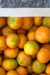 Wooden crate filled with fresh tangerines. Top view.
