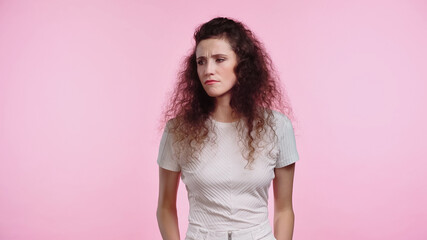 displeased young woman looking away isolated on pink