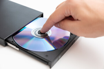 External DVD drive reader, man putting disc - obrazy, fototapety, plakaty