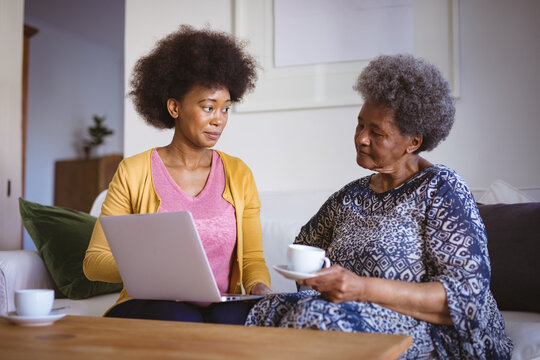 African american senior woman with adult daughter using laptop