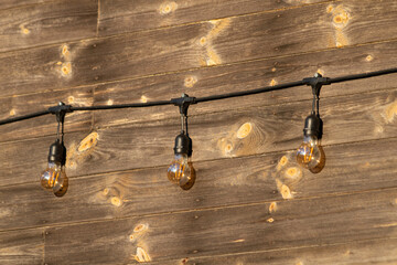 garden lighting. Outdoor string lights attached to the wall of a wooden house