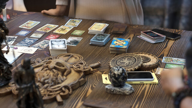 Tarot card reader arranges cards in a card spread. Fortune-telling concept