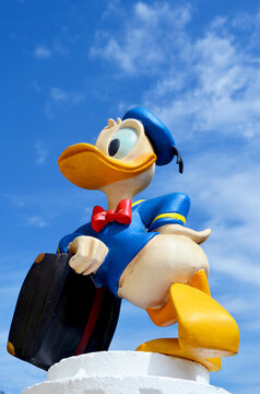 Donald Duck statue with a sky blue background.