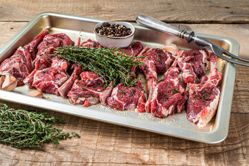 Raw uncooked lamb mutton meat chops steaks with thyme and garlic. Wooden background. Top view