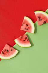 Flat lay top view watermelon in sunlight. Sliced fruit on green and red background