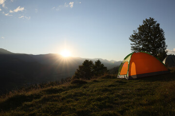 Color camping tent on hill in mountains