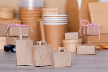 three paper bags on the background of boxes and paper cups