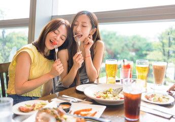 Happy  girlfriends enjoying food and drink in the restaurant