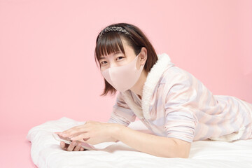 マスクを着けてスマホを操作する女性