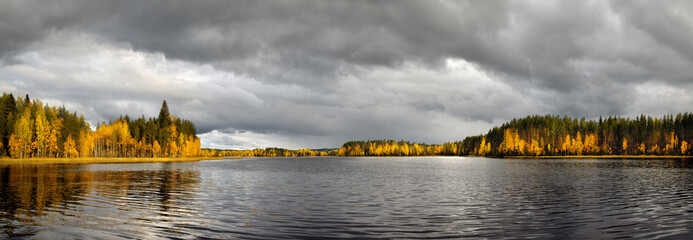 Panoramic view of beautiful forest lake in Finland. Autumn landscape, trees in fall colors.