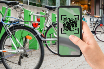 technology, transport and sustainability concept - close up of hand holding smartphone with qr code...