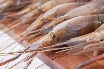close up of king prawn on a chopping board on table.