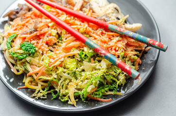 Cooked chicken breast pieces with egg noodles, carrots, and cabbage in a savory chow mein sauce