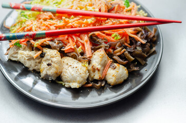 Cooked chicken breast pieces with egg noodles, carrots, and cabbage in a savory chow mein sauce