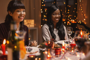 Obraz na płótnie Canvas holidays, party and celebration concept - happy women having christmas dinner at home