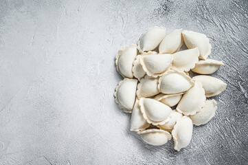 Raw frozen dumplings pierogi on a kitchen table. White background. Top View. Copy space