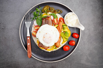 kebab with bacon and fried egg, tomato, spinach, avocado, pickled peppers
and sauce delicious on the plate