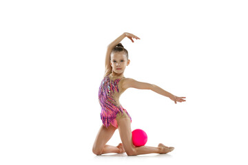 Full-length portrait of little girl, rhytmic gymnast training, exercising with ball isolated over...