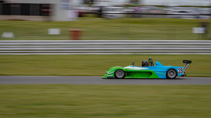 A panning shot of a racing car as it circuits a track.