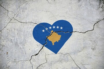 The flag of Kosovo symbolizes a heart on a cracked concrete wall.