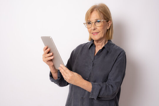 Happy Senior Woman Using Tablet Computer Isolated Over White Background.