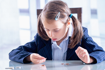 Sad and depressed business child girl counts coins. Concept of money, business, inflation and...