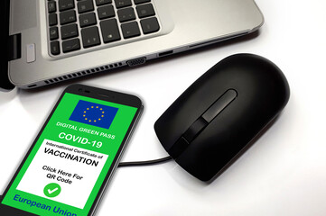 Covid-19 green passport. The digital green pass of the European Union on the screen of a smartphone with notebook and mouse. Safety concept at work with Green Pass for Covid-19