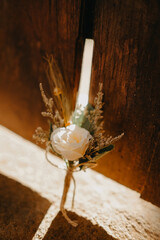 flower wedding corsage at the ground in brown fence under the shadow in the morning