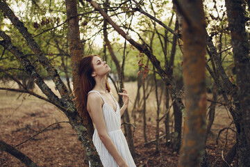 pretty woman in white dress in the forest near the trees rest