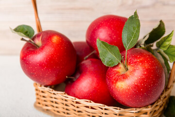 Ripe garden apple fruits with leaves in basket on wooden table. Top view flat lay with copy space