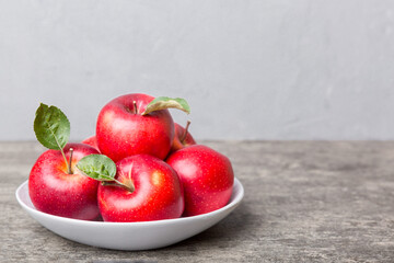 juicy red apples in a bowl or plate on the table top view. Copy space