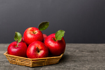 Fototapeta na wymiar Ripe garden apple fruits with leaves in basket on wooden table. Top view flat lay with copy space